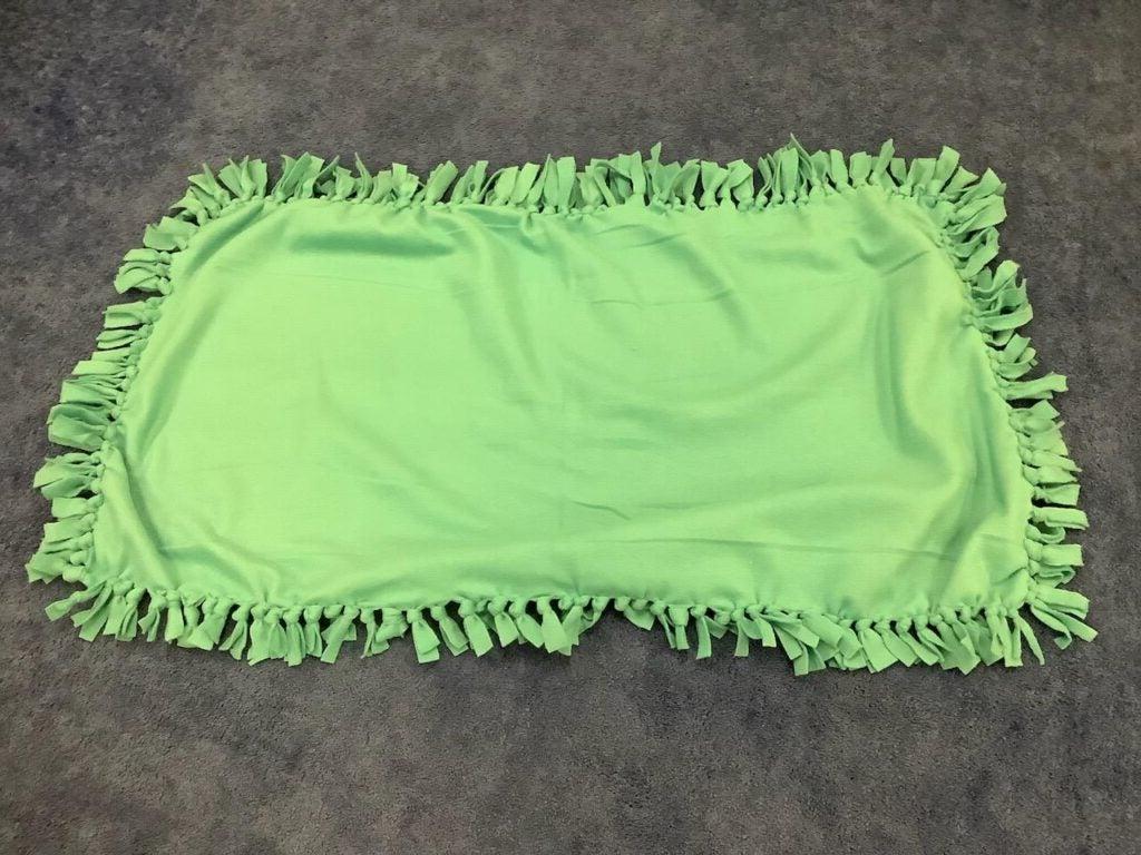 One lime green tie blanket, unfolded