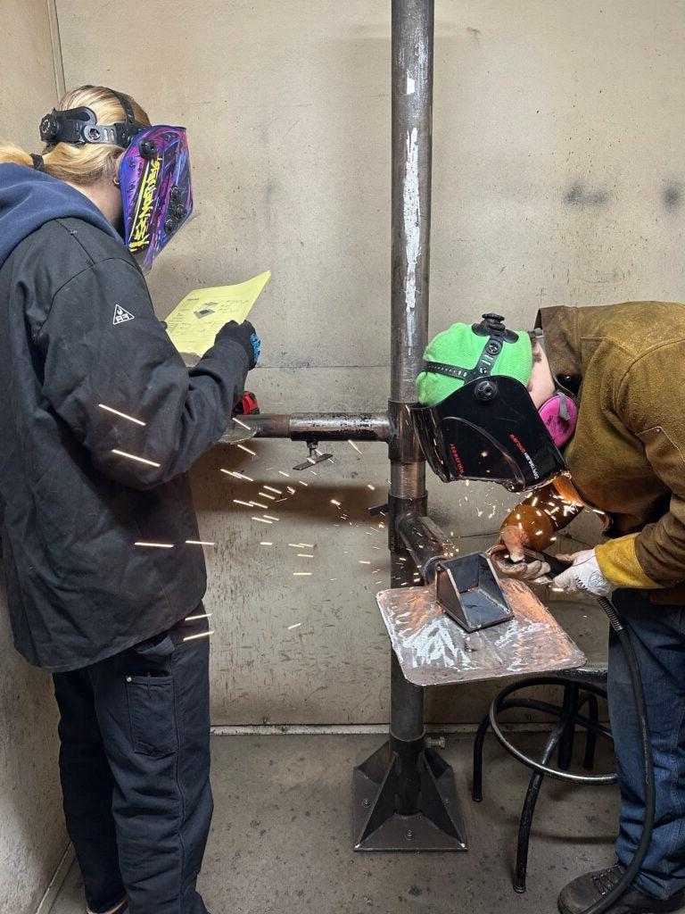Two students welding at SkillsUSA event in Everett